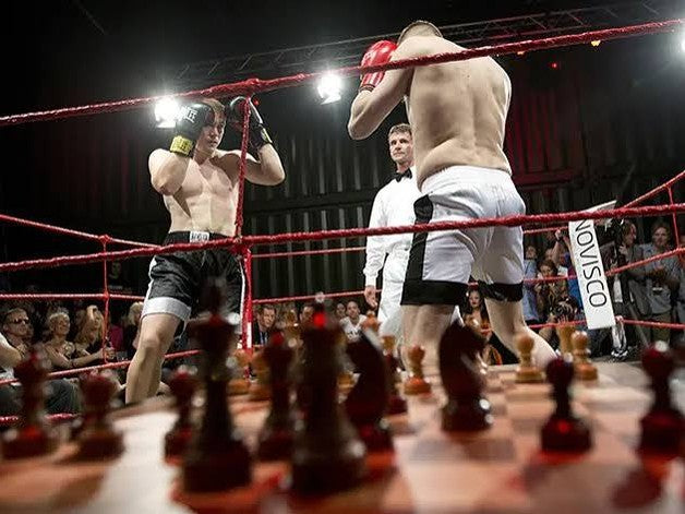 A chessboxing bout in the ring, board in the foreground